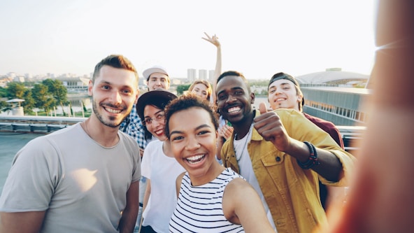 A diverse group of friends taking a selfie outdoors.