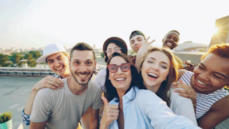 A diverse group of friends taking a selfie outdoors.