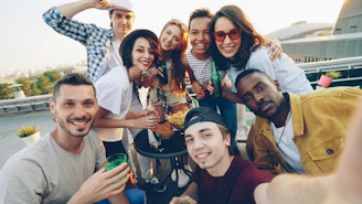 Diverse group of friends taking a selfie on a rooftop.