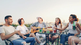 Friends enjoying a rooftop party with music and drinks