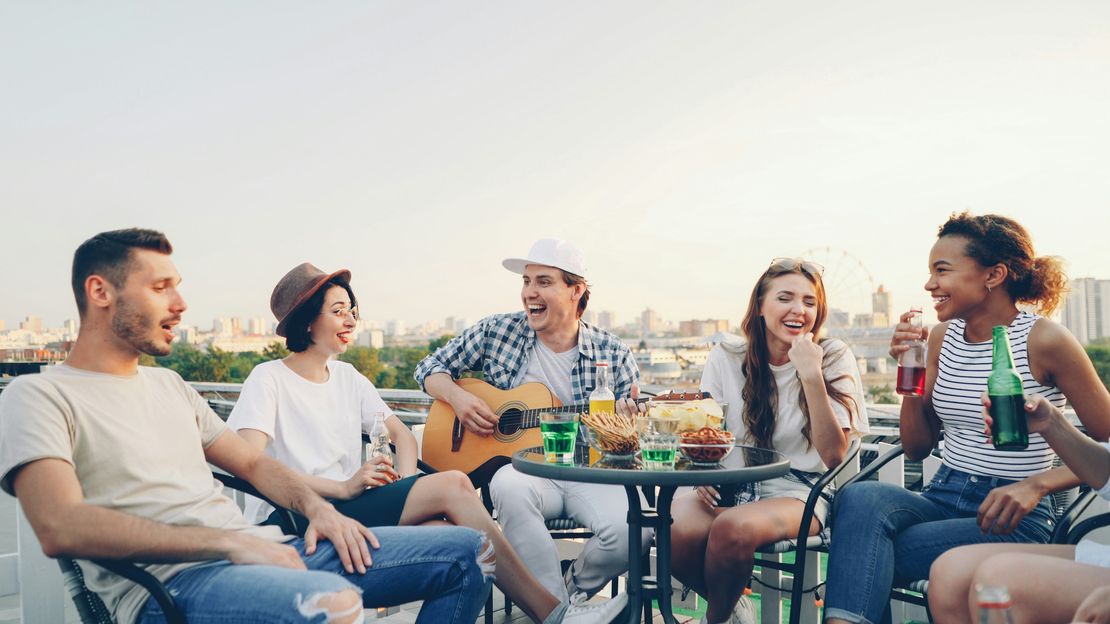 Friends enjoying a rooftop party with music and drinks