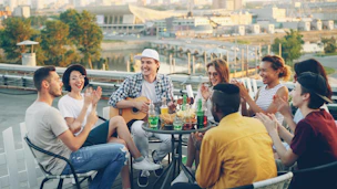 Friends enjoying a rooftop party with music and drinks