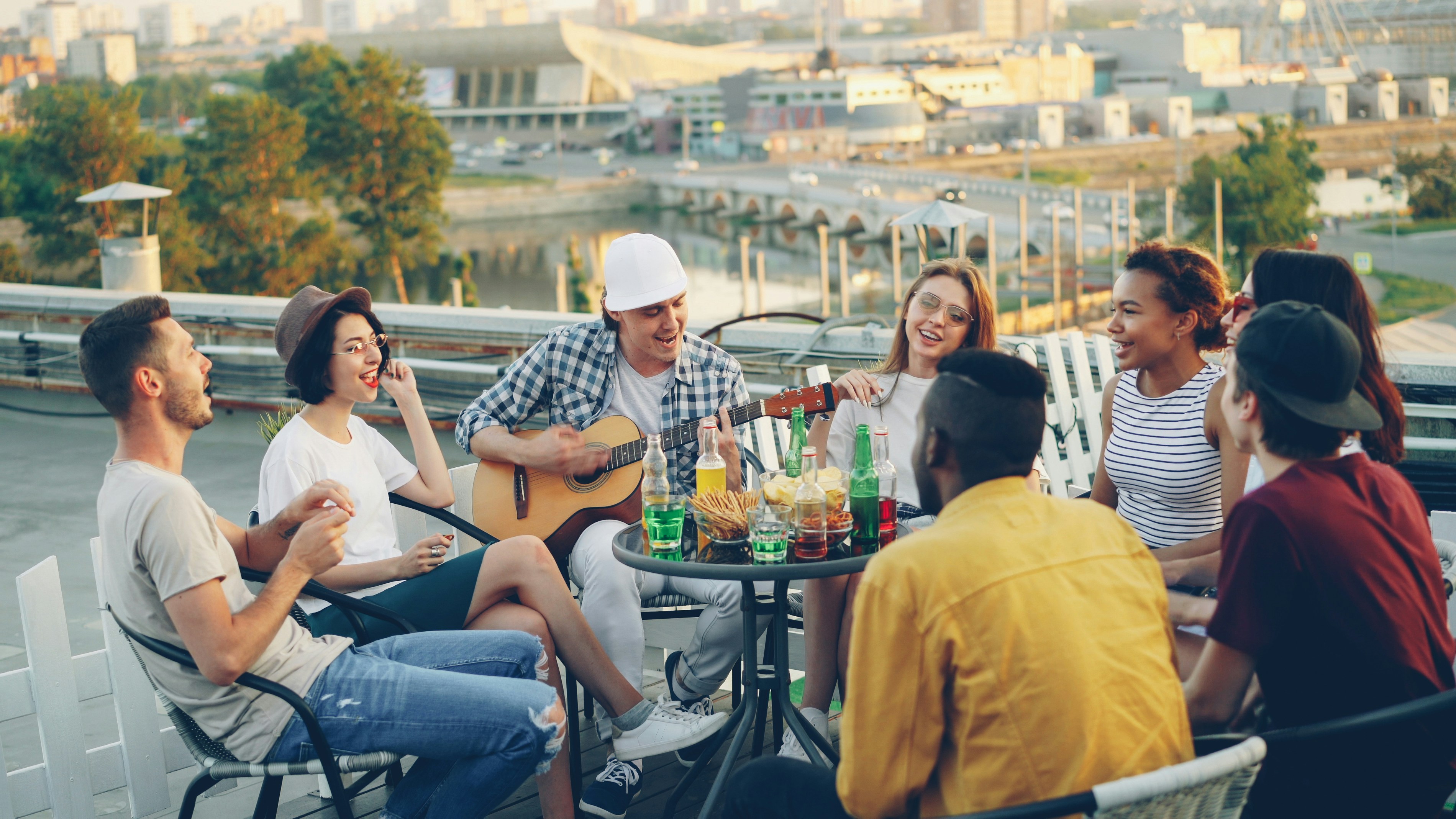 Friends enjoying a rooftop gathering with music and drinks