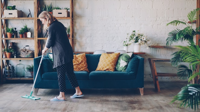 Woman cleaning the floor in a modern living room.