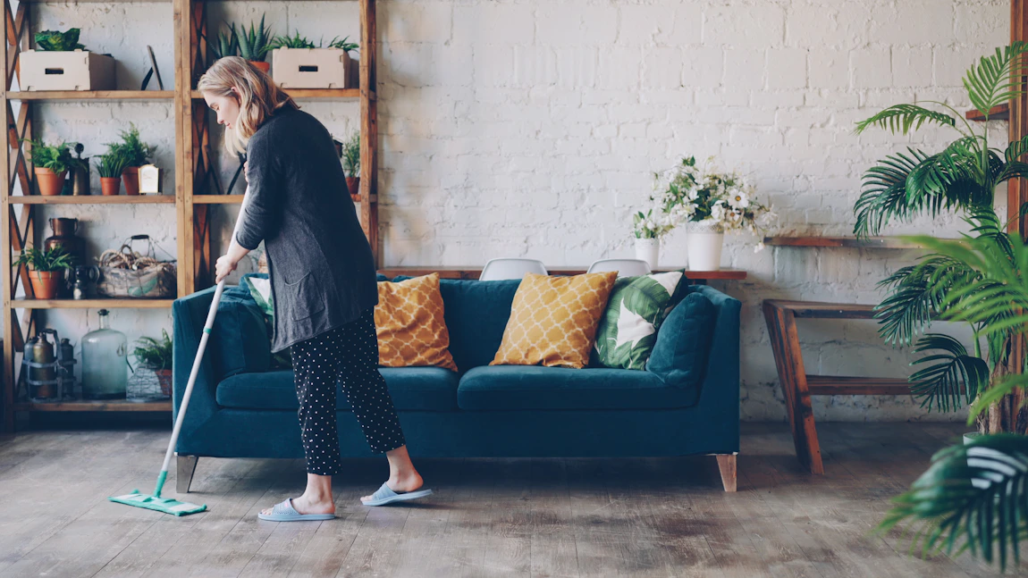 Person mopping a living room floor