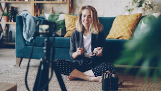 Woman recording video with camera in living room