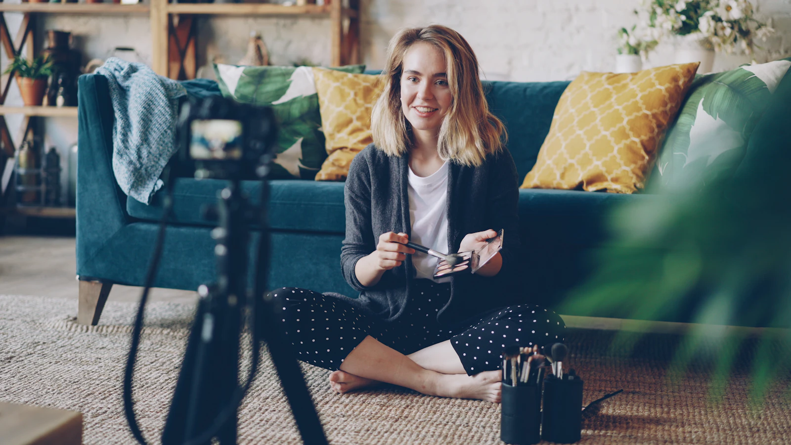 Course creator filming a lesson with a camera in a bright living room