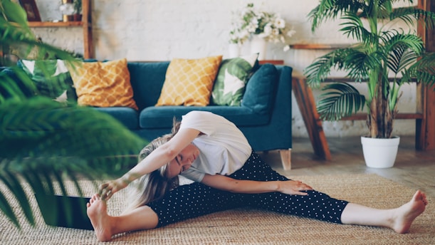Woman stretching on floor in a living room.