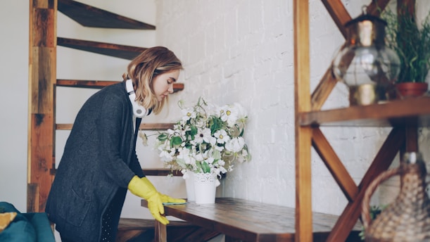 Woman in yellow gloves cleaning a shelf