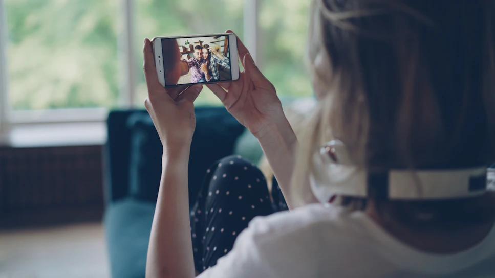 Woman watching video on smartphone indoors