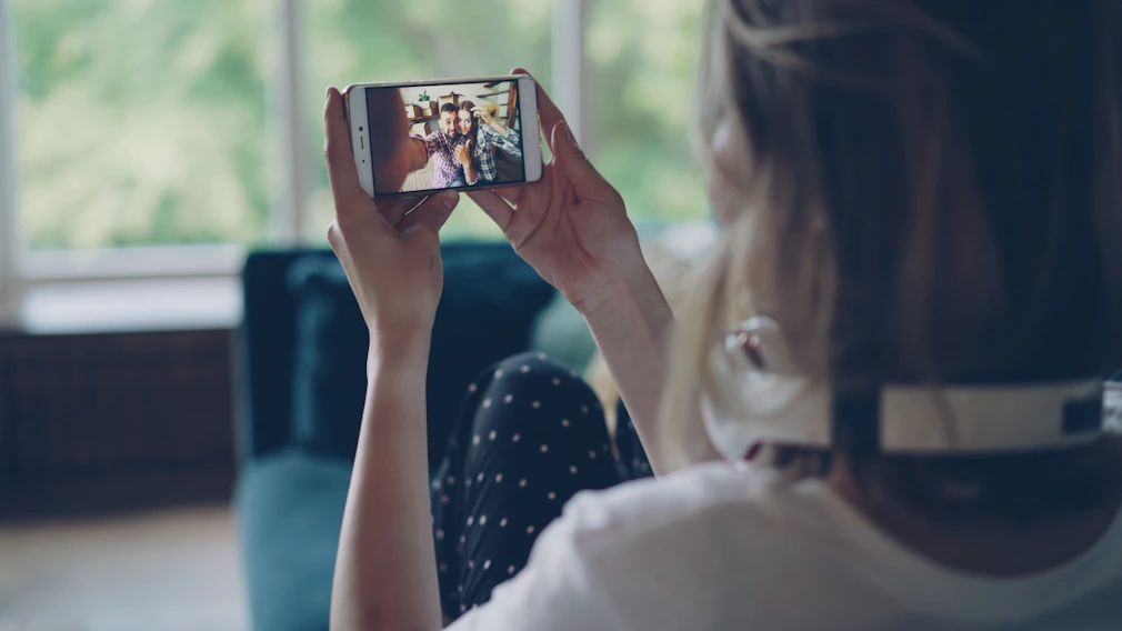 Woman watching video on smartphone indoors