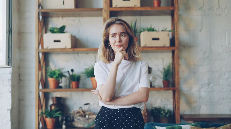 A young woman with hand on chin looking thoughtful