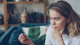 Young woman looking at a small object in her hand.