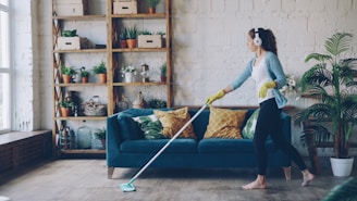 Woman with headphones mopping a wooden floor