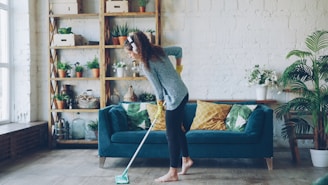 Woman mopping floor while wearing headphones.