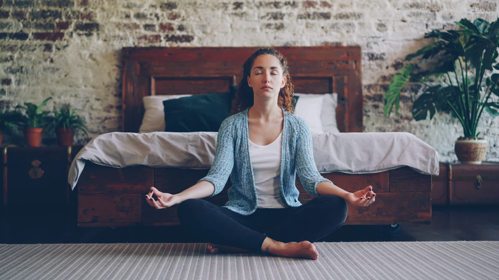 A woman in calm seated meditation at home
