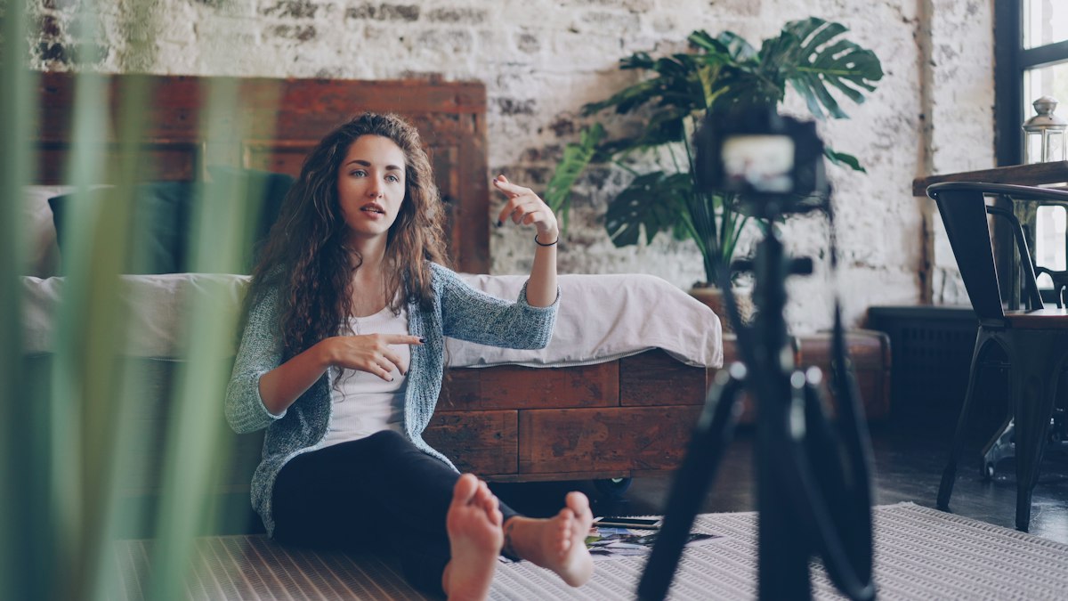 A vlogger records an emotive, gesture-driven video review at home.