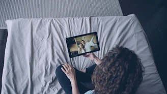 Woman watching video on tablet in bed.