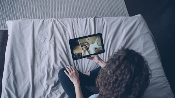 Woman watching video on tablet in bed.