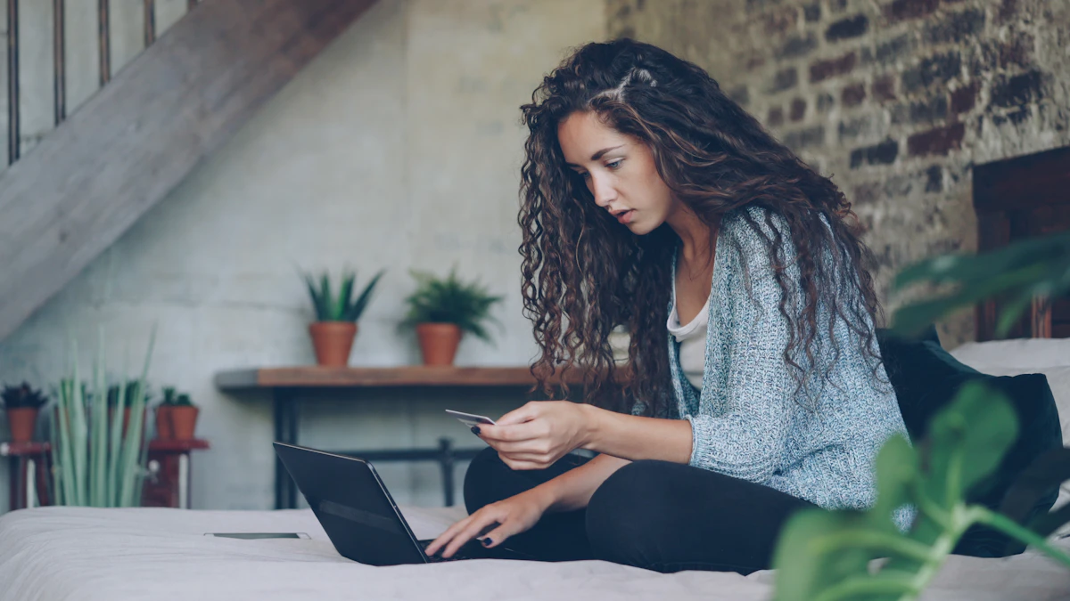 laptop ပေါ်တွင် အွန်လိုင်းငွေပေးချေမှုအတွက် ခရက်ဒစ်ကတ် အသုံးပြုနေသော လက်များ