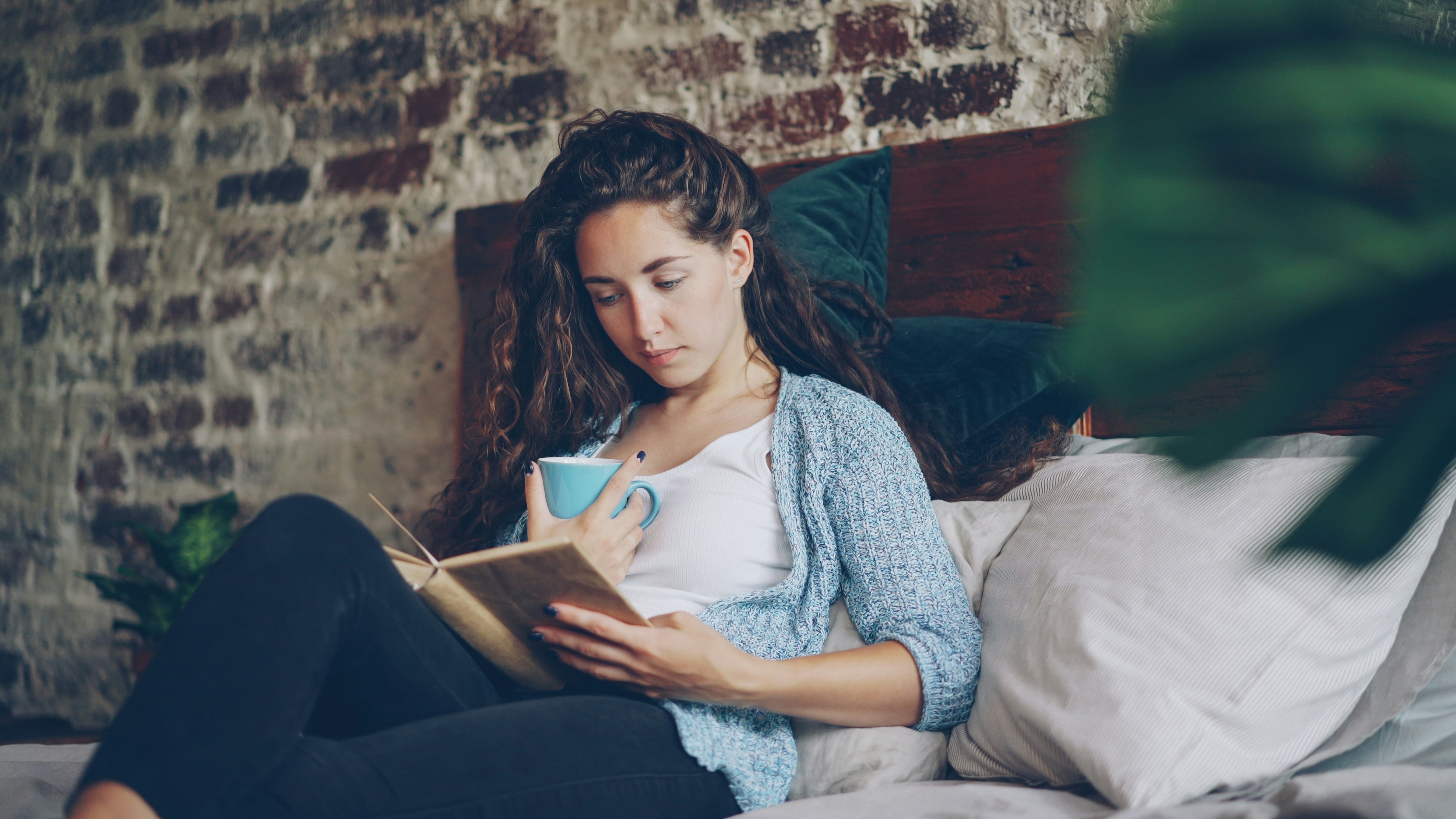 Woman reading a book with a cup of coffee.