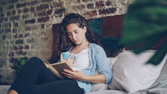 Woman reading a book with a cup of coffee.