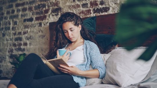 Woman reading a book with a cup of coffee.