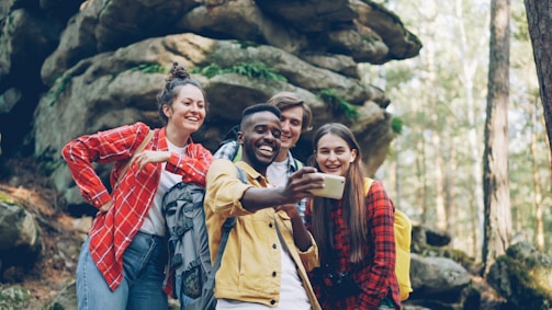 Four friends taking a selfie in a forest