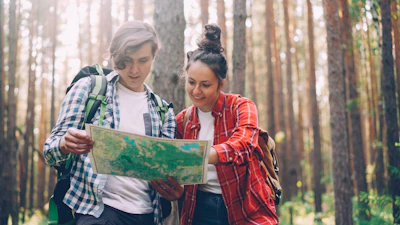 Two hikers looking at a map in a forest