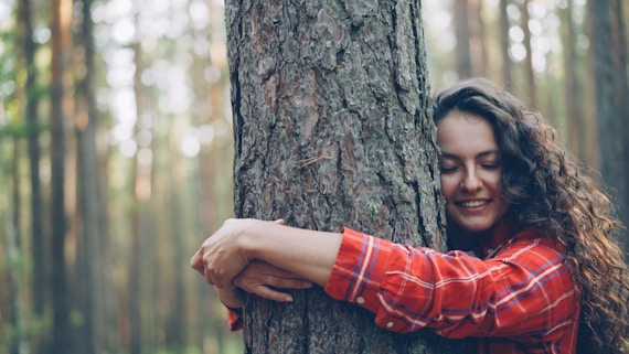 Woman hugging a tree in a forest