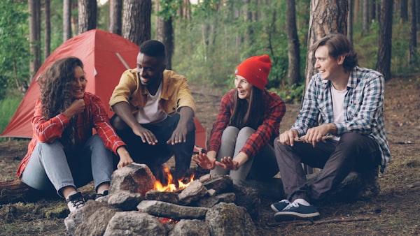 Group of teenagers laughing and having fun together in the forest