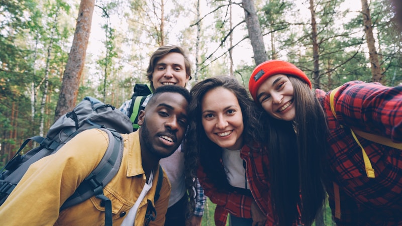 Four friends taking a selfie in a forest.