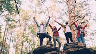 Four friends celebrating on rocky terrain outdoors