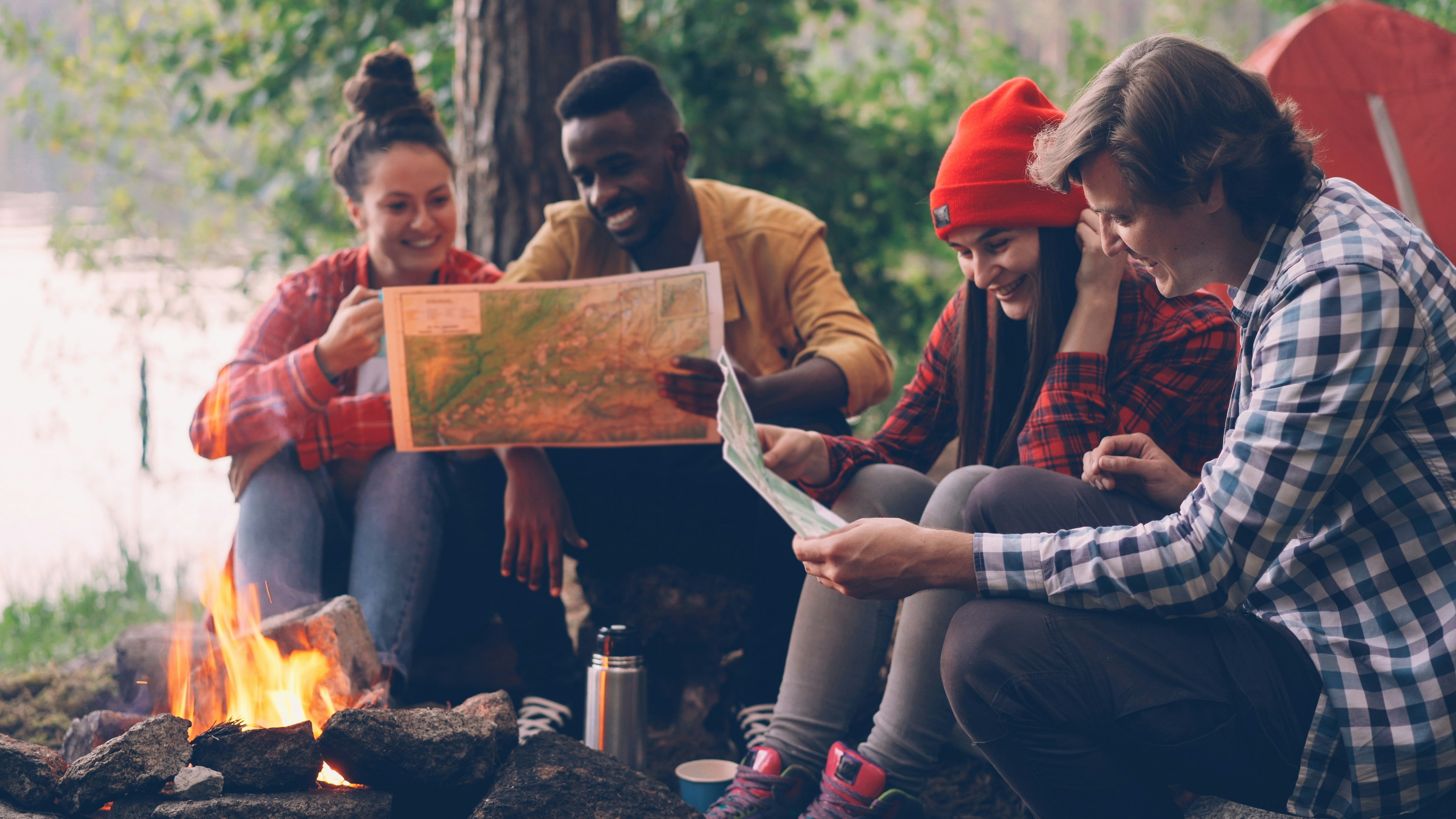 Young people discussing technology ethics around a campfire