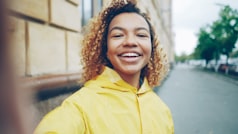 Joven sonriente mirando su smartphone en casa