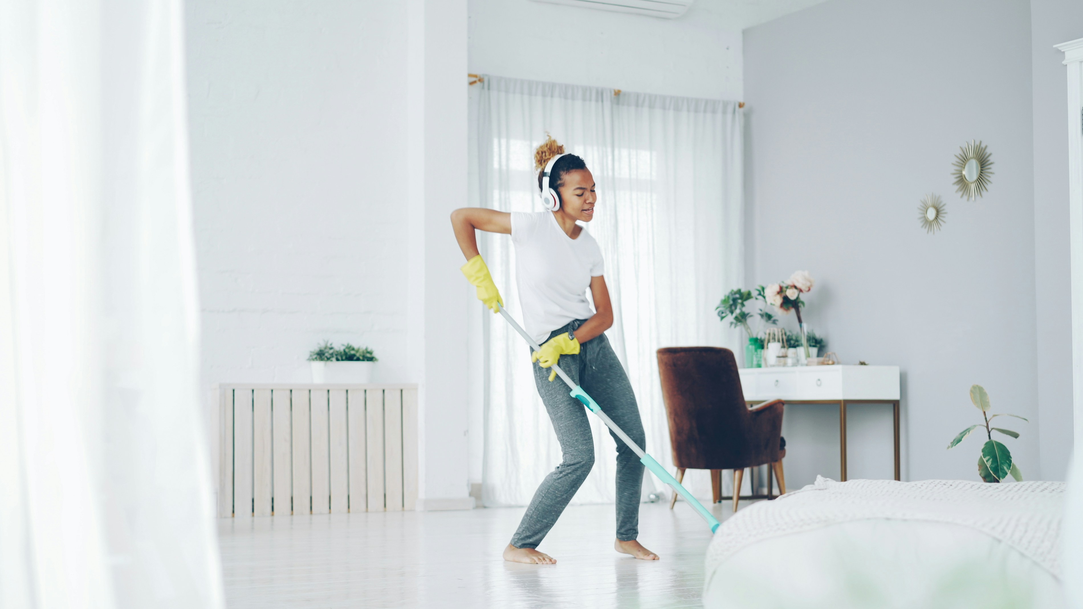 Woman dancing while cleaning with a mop