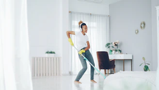 Woman dancing while cleaning with a mop