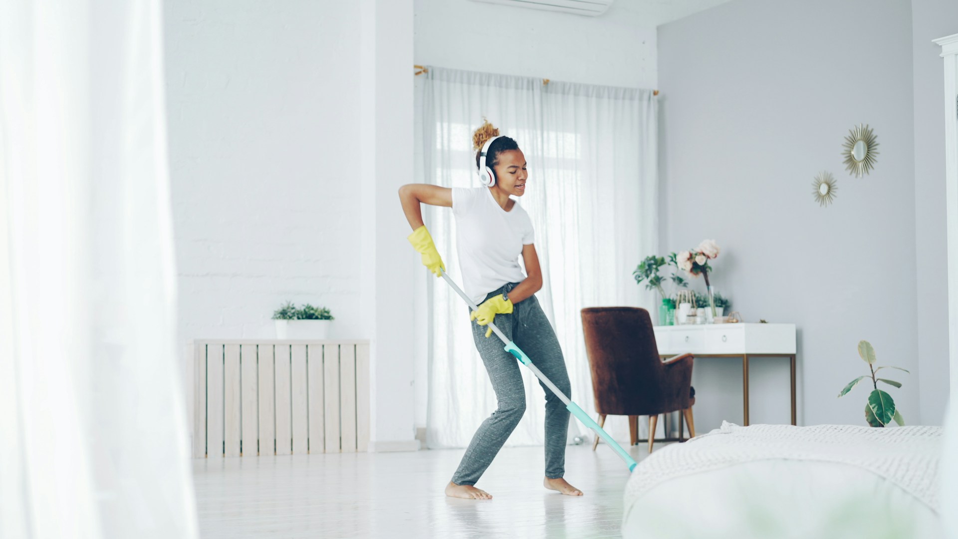 Woman dancing while cleaning with a mop