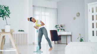Woman happily mopping the floor while dancing