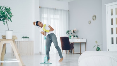 Woman happily mopping the floor while dancing