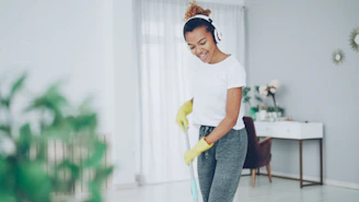 Woman with headphones cleaning floor with mop