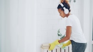 Young woman with headphones cleaning a shelf