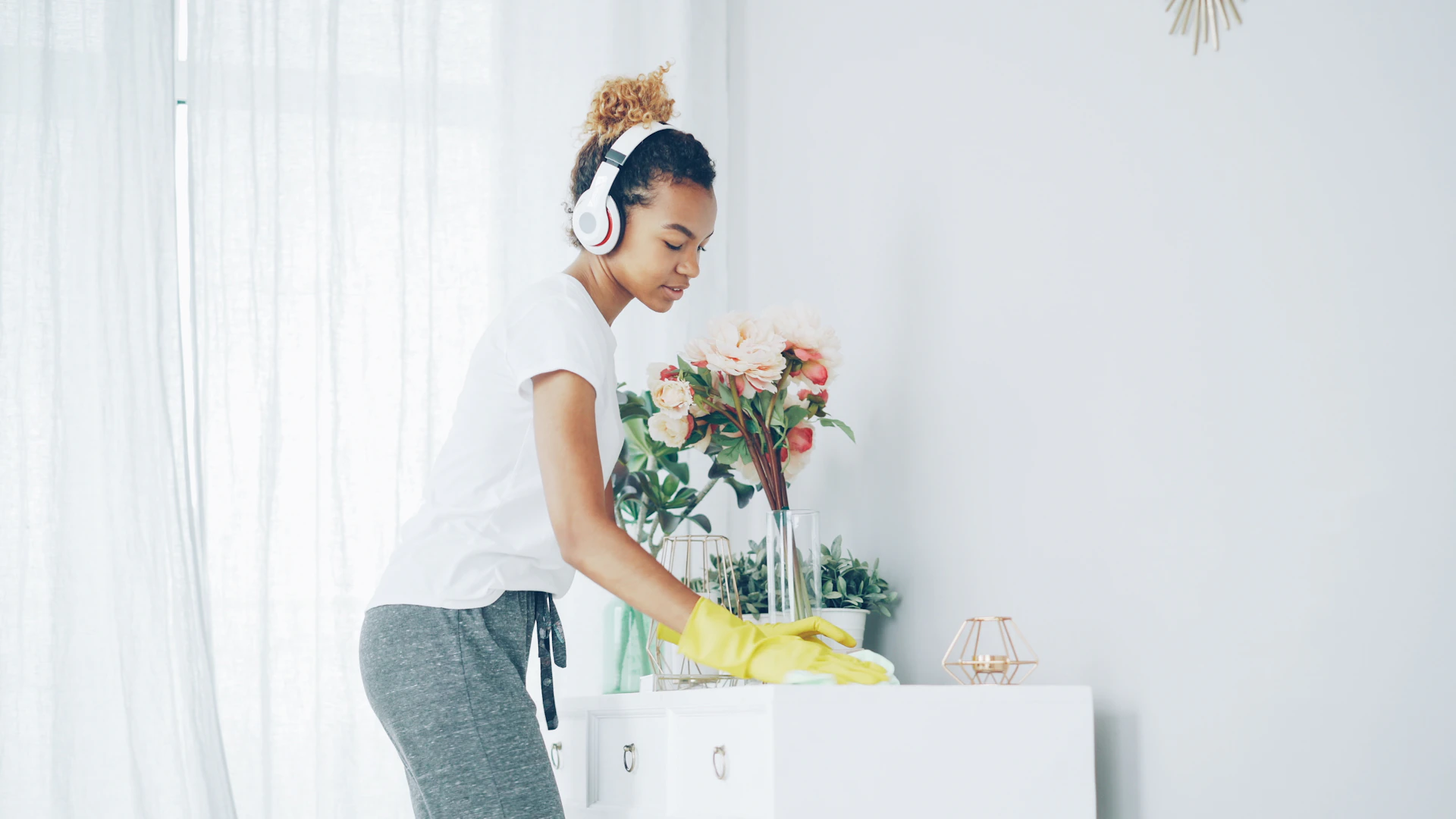 Woman with headphones cleaning a shelf