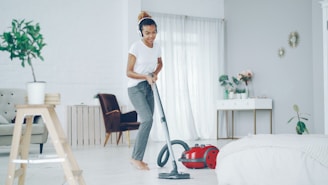 Woman happily vacuuming a bright, modern room