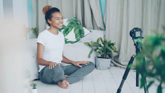 A woman records herself with a camera at home.