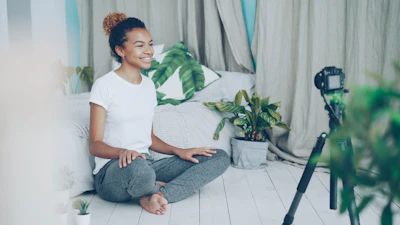 A woman records herself with a camera at home.