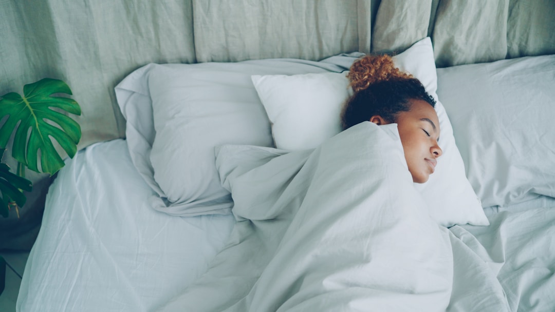 A woman sleeping peacefully in a comfortable bed with soft lighting