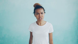 Woman with a confused expression against a blue background