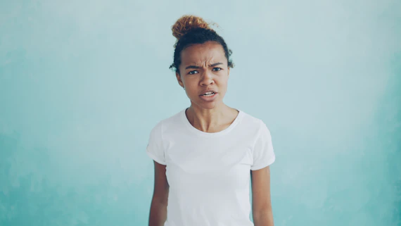 Woman with a confused expression against a blue background