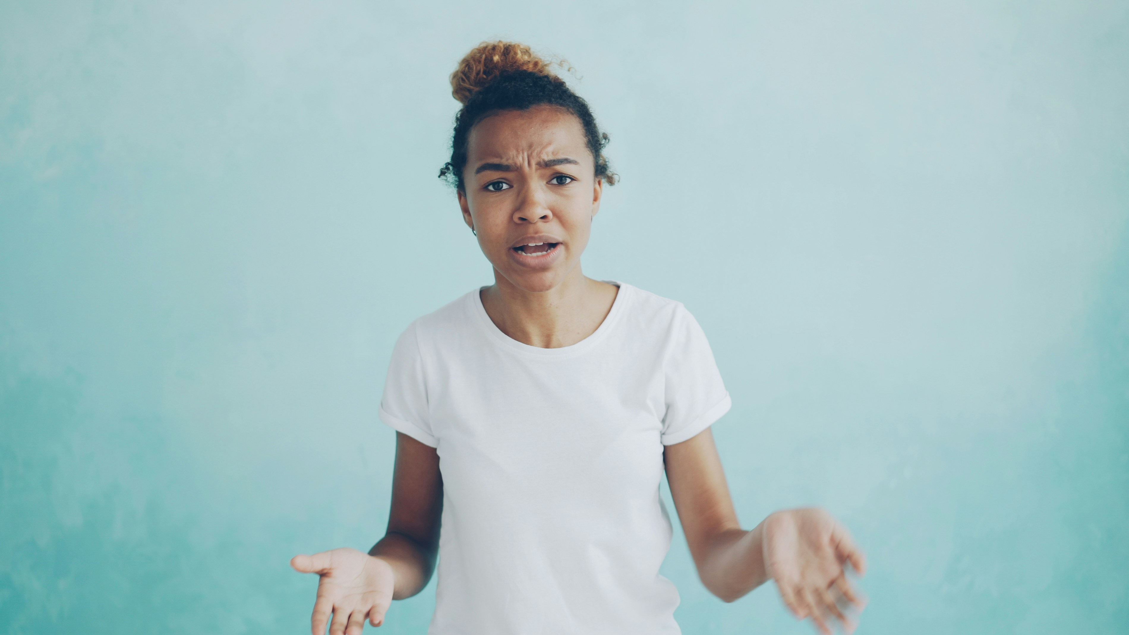 Young woman with exasperated expression against blue background